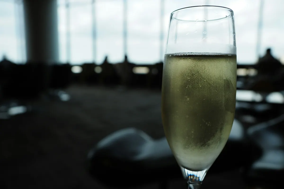 Glass of champagne on a table in a softly lit private jet cabin